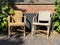 View on two empty old braided rattan chairs, brick wall background