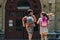 View of two schoolkids with backpacks running in schoolyard