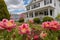 view of two-story colonial with blooming spring flowers