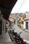 View of typical narrow street of El hatillo, people walking on the sidewalk, motorcycles one after another parked and in front on