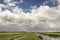 View on typical scenic Dutch landscape in het Groene Hart of the Netherlands with heavy clouds in the blue sky, lots of grassland,