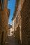View of typical stone houses with sunny blue sky, in a narrow alley of Lourmarin.