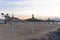 View at umbrellas with straw cover, empty sandy beach at sunset