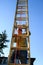View from under an aluminum extension ladder, senor man climbing ladder on sunny day