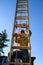 View from under an aluminum extension ladder, senor man climbing ladder on sunny day