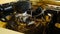 View under hood of retro car on engine with carburetor and black air filter housing. Beige car, vintage build