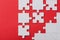 View of unfinished jigsaw puzzle pieces isolated on red