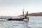 View of unrecognizable woman wearing big summer sun hat tanning topless and relaxing on old wooden pier in remote calm