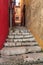 View up on stairs in narrow street between new red and shabby ye