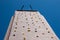 View up to top of a high artificial climbing wall