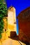 View upstairs over steps and narrow alley on fortress ochre church tower against blue sky - Roussillon en Provence, France