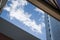 A view upwards through buildings of a blue sky