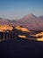 View of the Valley of the Moon in San Pedro de Atacama at sunset. In the background the volcano Licancabur and the Juriques