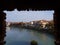 A view on Verona through the rough brick bridge window