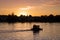 View on a very romantic part of the city Potsdam, small boat swimming on the Havel, towards the sunset