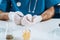 View of veterinarian in latex gloves holding white mouse near container with medicine