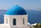 View from viewpoint of Oia village with blue dome of  greek orthodox Christian church. Santorini,