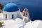View from viewpoint of Oia village with blue dome of greek orthodox Christian church. Santorini,