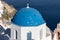 View from viewpoint of Oia village with blue dome of  greek orthodox Christian church. Santorini