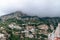 View of the village high in the mountains. Thick gray clouds cover the top. Highland Housing Concept. Olive plantations, houses