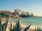 View of the villas on a cliff above Altafulla beach in Tarragona Catalonia, Spain. Large aloe on the sand, emerald water of the