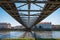 View of the Vistula River from under the footbridge. Beautiful historic tenement houses on the other side of the river. The steel