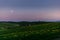 View of the Vitaleta Chapel and the surrounding hills of the Orcia Valley near San Quirico d\\\'Orcia under the moon at sunset