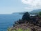 View of volcanic rocky coast and the sea with reflection of the sunlight