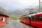 View of Voss mountain train stopped at Myrdal train station with snowy peaks on backgound, Norway