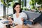 View of waiter holding credit card reader near cheerful woman paying with smartphone