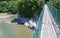 View of walking suspension bridge and mountain river of left