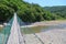 View of walking suspension bridge and mountain river of right