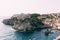 View from the wall of the old city of Dubrovnik on the fort Lovrijenac fortress on the cliff and the bay with a pier.