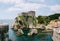 View from the wall of the old city of Dubrovnik on the fort Lovrijenac fortress on the cliff and the bay with a pier.