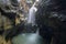 View of a waterfall in a deep narrow canyon known as Gouffre des Busserailles in Aosta valley near Breuil-Cervinia, Italy