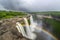 view of waterfall with rainbow, captured during stormy weather