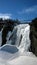 view of a waterfall under a beautiful winter day in Quebec Canada