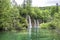 View of waterfalls with turquoise water and green trees in Plitvice Lakes National Park in summer, Croatia