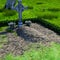 View of a well-kept grave in a large cemetery with a massive cross in the summer