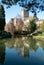 View of Wells Cathedral reflected in Wells Pool in the gardens at The Bishop`s Palace in Wells, Somerset UK.