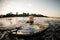 view of wet woman in wetsuit in the water leaning on wakeboard