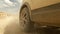 View of the wheels of a dirty SUV car in motion, creating dust. An exciting road adventure