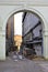 View through a white classic arch in an old alley with pipes on walls