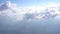 View of the white clouds above the ground from the airplane window