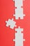 View of white connected jigsaw near puzzle piece isolated on red