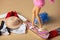 View on white female doll legs next to big clothes mess on a floor
