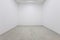 A view of a white painted interior of an empty room or an art gallery with a fluorescent lighting and wood floors