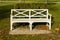 View of white Patio wooden Bench in the green park garden in the fall season