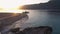 View of wild tropical island beach at sunset. Boat on the shore with mountains on the background.