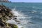 View of wild waves crashing on the rocks on the boulevard of Tel-Aviv Israel. In the distance the old city of Jaffa beech, on the